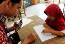 Para assessor USAID PRIORITAS sedang mengukur kemampuan membaca siswa sekolah dasar di Bantaeng
