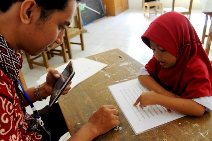 1-1610 Para assessor USAID PRIORITAS sedang mengukur kemampuan membaca siswa sekolah dasar di Bantaeng